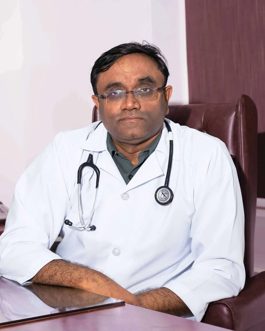 Dr. Anil Srivastava in his white coat at his consulting desk