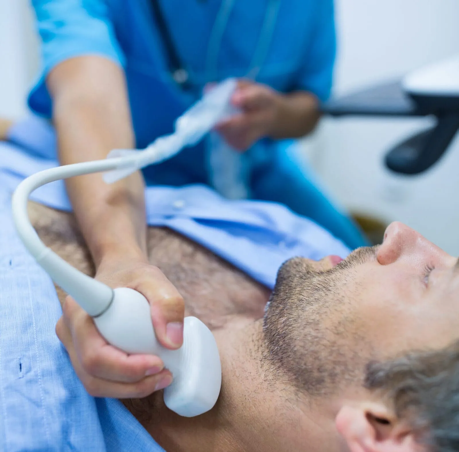 A doctor performing a thyroid ultrasound on a patient